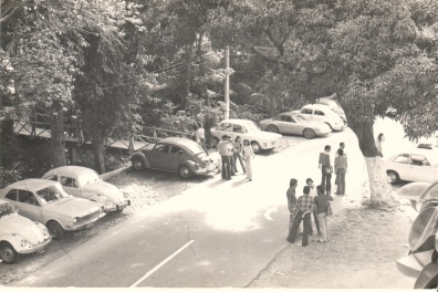 Vista da via de passagem principal da PUC-Rio e da primeira ponte de acesso ao Edifício da Amizade, com alunos e carros. 1980. Fotógrafo Antônio Albuquerque. Acervo da Vice-Reitoria de Desenvolvimento. Vista da via de passagem principal da PUC-Rio e da primeira ponte de acesso ao Edifício da Amizade, com alunos e carros. 1980. Fotógrafo Antônio Albuquerque. Acervo da Vice-Reitoria de Desenvolvimento.